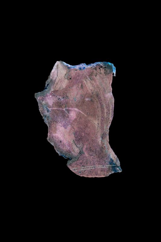 Frammento di minerale rosa e violaceo su fondo nero