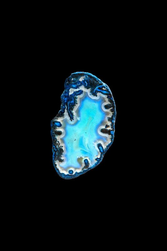 Geode dal cuore azzurro turchese con bordo cristallino su fondo nero